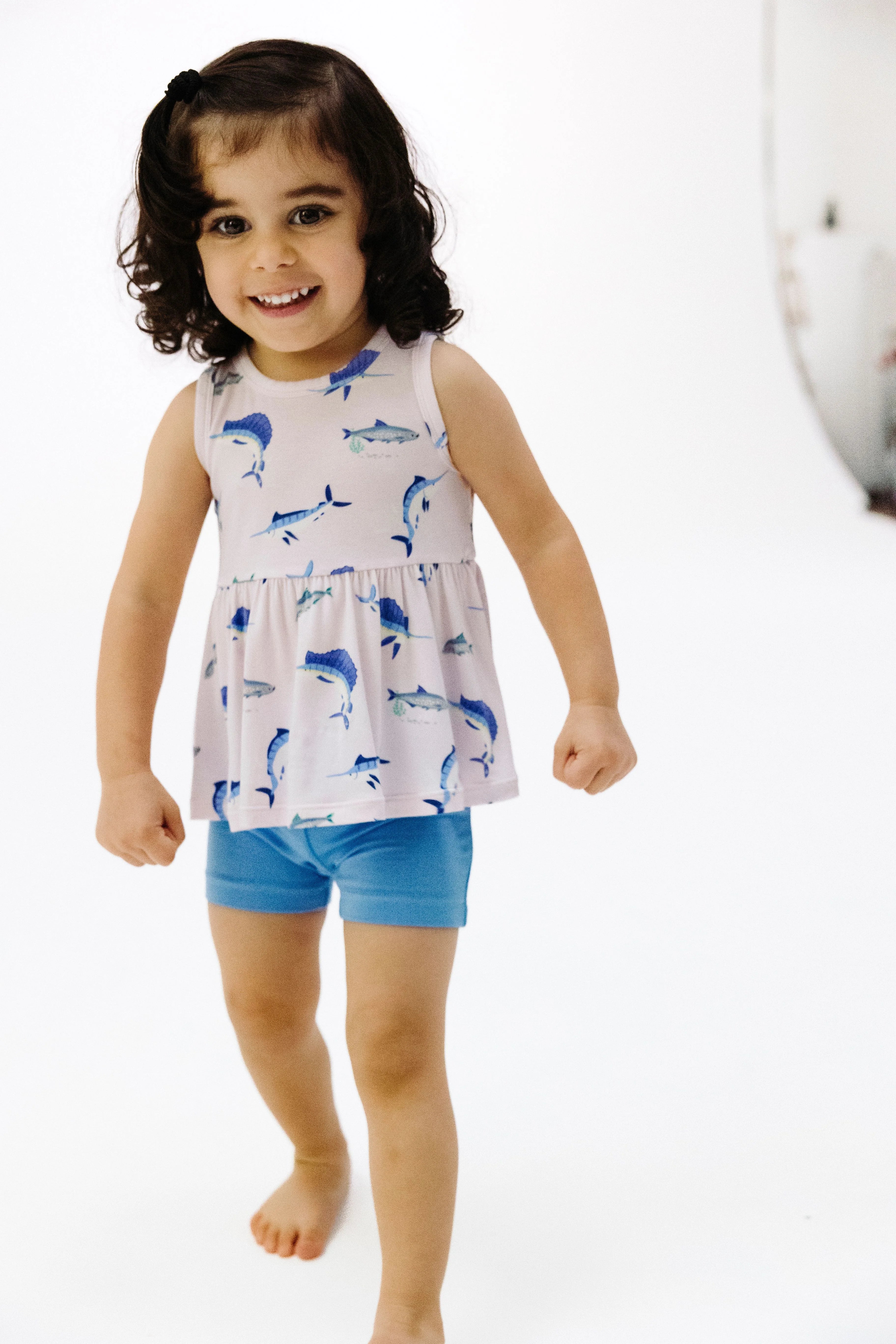 pink tank top with fish print and blue shorts