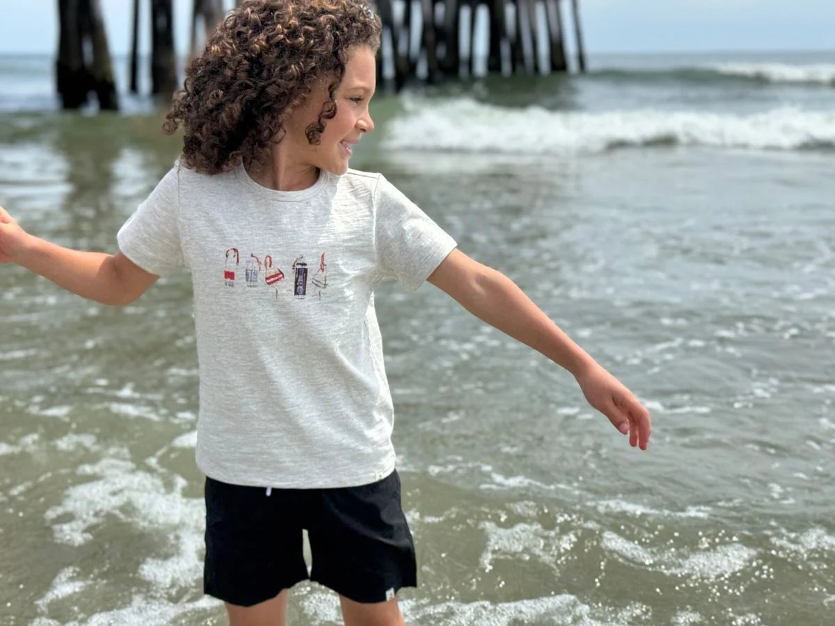 boy wearing buoy shirt on the beach