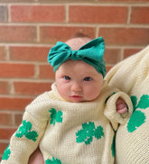 ivory roll neck sweater with green shamrocks knitted all over