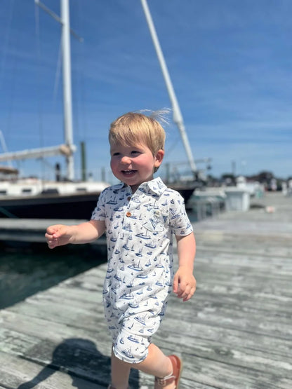 little boy wearing the romper on a dock