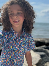 boy wearing buoy shirt on beach