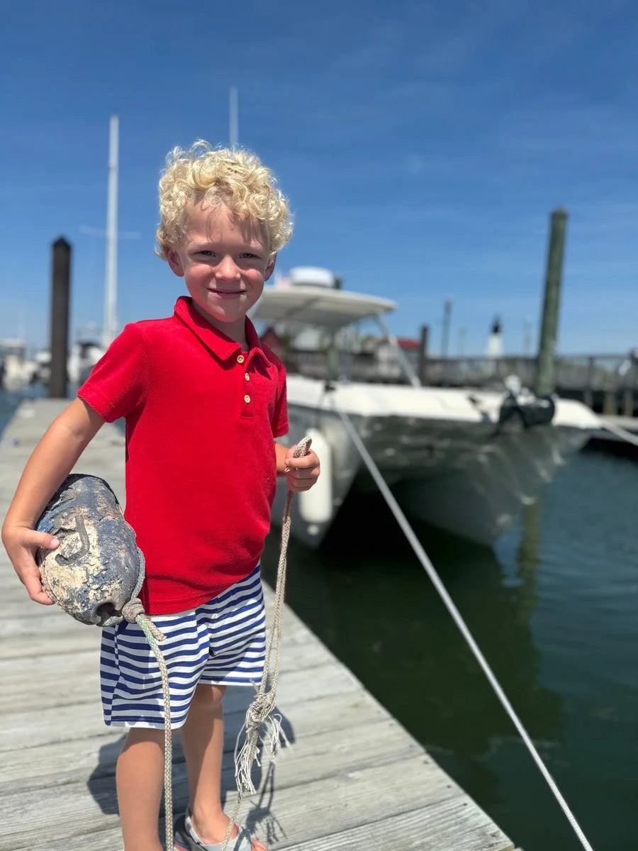 boy wearing red polo shirt at the beach