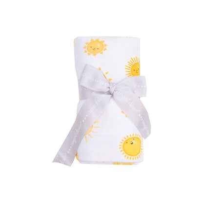 white swaddle blanket with yellow suns all over