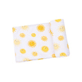 white swaddle blanket with yellow suns all over