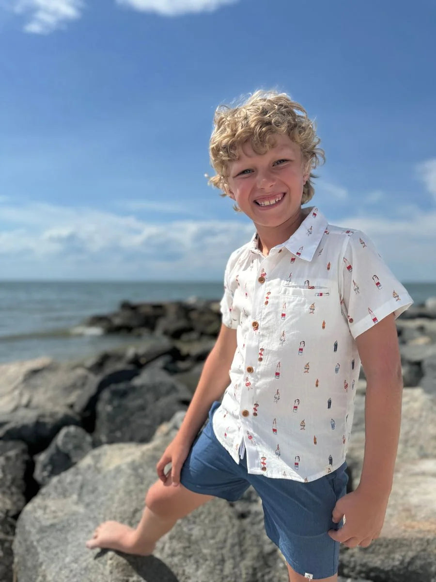 boy wearing buoy shirt on beach