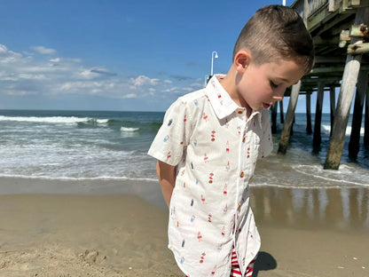 boy wearing buoy shirt on beach