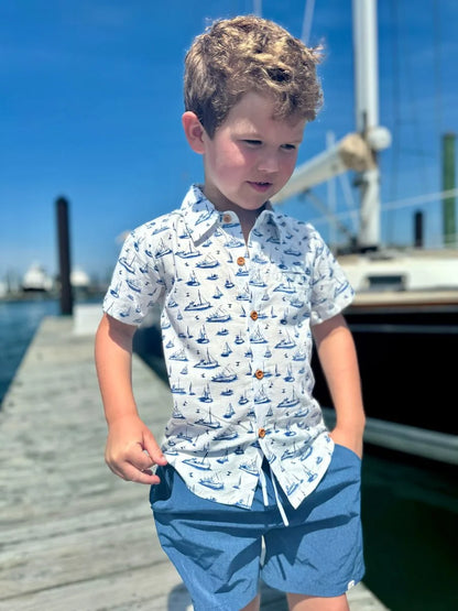 boy wearing sailboats shirt on dock