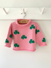 pink shamrock sweater hanging on a peg