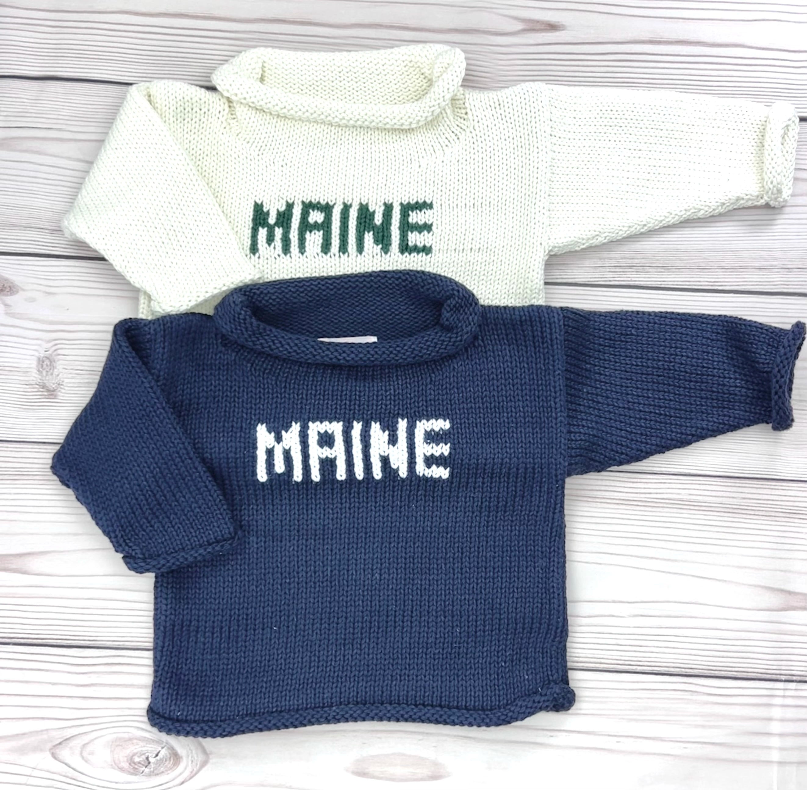 maine sweaters - one is ivory with green writing and one is navy with white writing