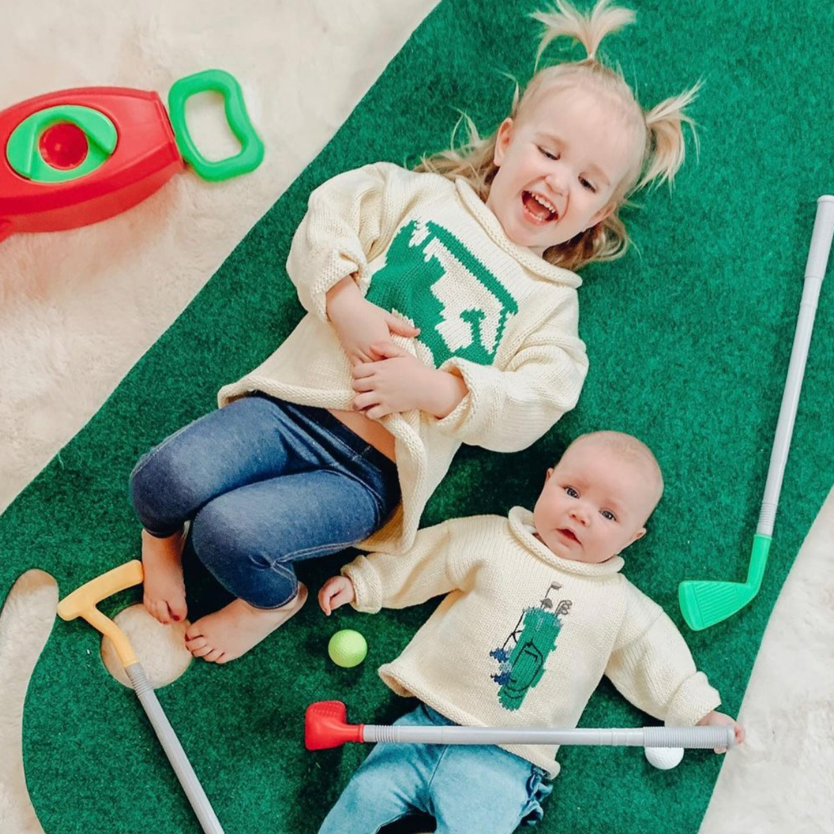 toddler wearing Golf Cart sweater and baby wearing Green Golf Bag sweater