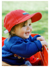 baby smiling wearing royal blue train sweater